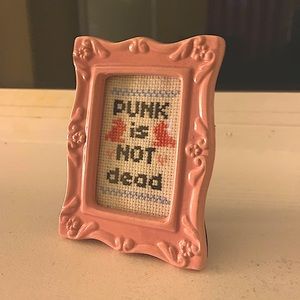 Framed crocheted “Punks Not Dead” home decor.